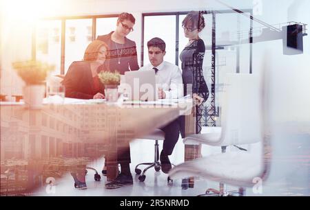 Building on a foundation of teamwork. a team of businesspeople in a meeting superimposed over a build site. Stock Photo