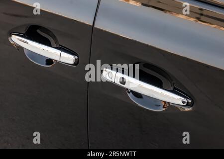 chrome car door handle with rubber keyless entry button to open the vehicle without looking for the key in the pockets wasting no time Stock Photo