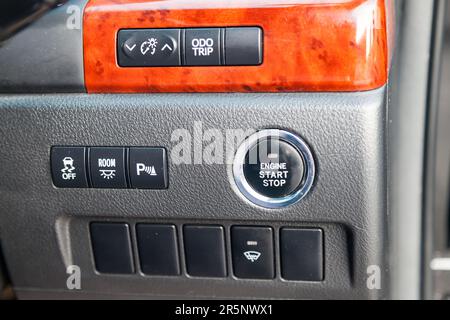 Button start and turn off the ignition of the car engine close-up on the dashboard, electric key, of modern design black and with elements chrome on t Stock Photo