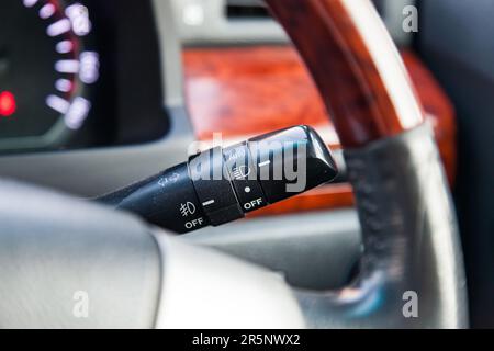 The lever for switching lights and turn signals under the steering wheel in a car Stock Photo