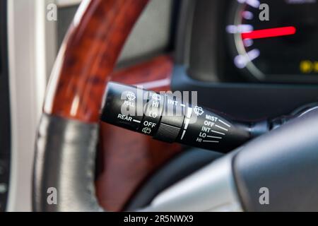 Wiper mode selection button with automatic adjustment through the rain sensor on the steering column of the car. The choice of weather. Stock Photo