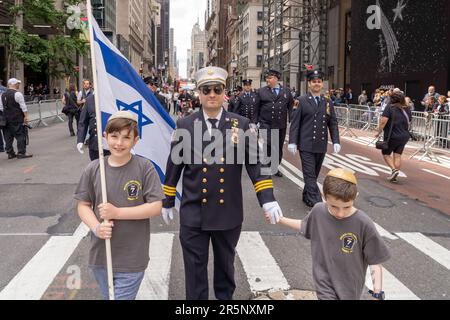 NEW YORK, NEW YORK - JUNE 04: A fire fighter march with his kids at the Celebrate Israel Parade on June 4, 2023 in New York City. Credit: SOPA Images Limited/Alamy Live News Stock Photo