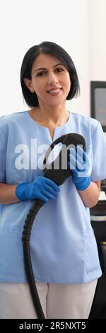 Portrait of laser hair removal master. Woman cosmetologist doctor holding device for laser hair removal in hands and looking at camera Stock Photo