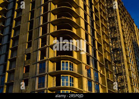 construction of a new multi-storey building. view in profile, the side of the house has a semicircular base. the insertion of new glass windows on the Stock Photo