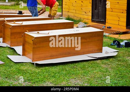 Workers assemble new wooden cabinets furniture in the street. Stock Photo