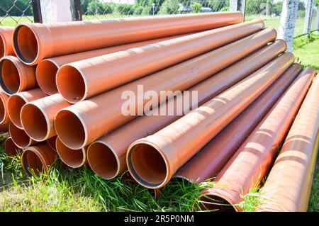 Orange plastic industrial polypropylene thick plumbing pipes with large diameter gaskets with flanges. Stock Photo