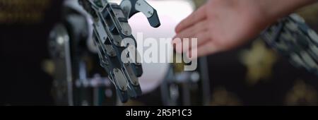 Businessman hand shaking hands with robot droid. Concept of human interaction with artificial intelligence. Stock Photo