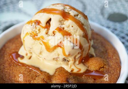 Closeup of Mouthwatering Skillet Cookie Topped with Ice Cream and Salted Caramel Sauce Stock Photo