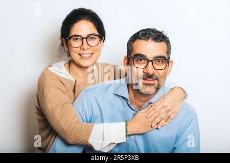 Studio portrait of happy couple wearing eyeglasses, posing together on white background Stock Photo