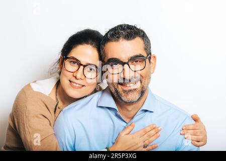 Studio portrait of happy couple wearing eyeglasses, posing together on white background Stock Photo