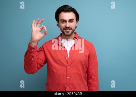 handsome confident dark haired 30s man in red shirt Stock Photo