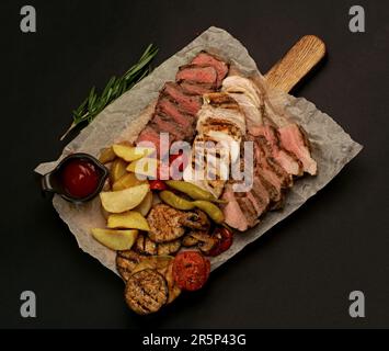 grilled meat. several types of grilled meat cut on a wooden board. Stock Photo