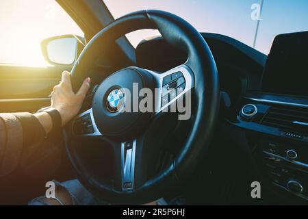 BMW G30 5-series M-package steering wheel. Woman is holding sport fast car steering wheel. 13.05.2023 Tallinn, Estonia Stock Photo