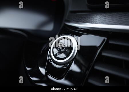 A vehicle engine start-stop system or launch button. Turn on or turn off the cars engine. Stock Photo