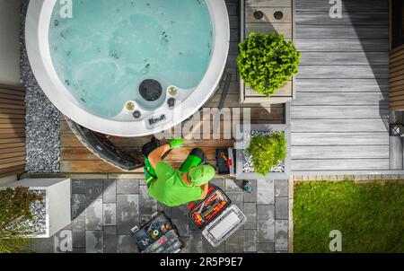 Aerial View of Hot Tub Technician Performing Garden SPA Repair During Seasonal Maintenance Stock Photo