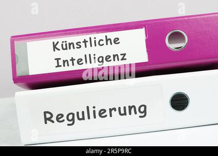 Folders with the words artificial intelligence and regulation, german language, AI technology in competition with human resource, manpower against cyb Stock Photo