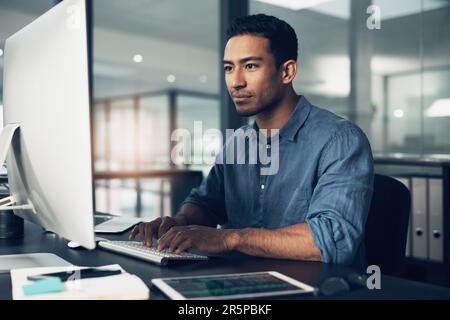 Typing, man and programmer on computer in office at night for deadline. IT, focus and male coder, engineer or person programming, coding and writing Stock Photo