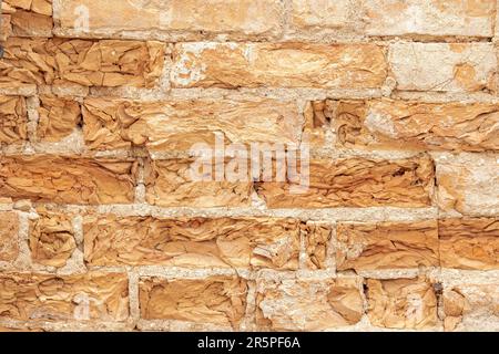 Background from an old brick wall with bricks crumbling from age Stock Photo