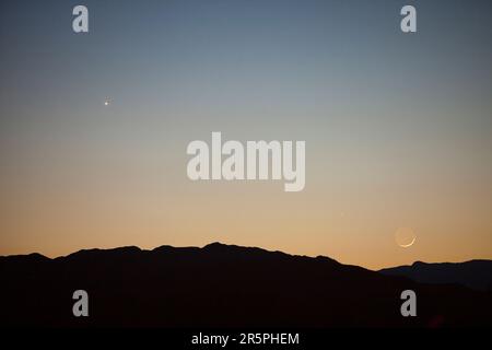 Venus, Mercury and a new moon over Loughrigg in the Lake District, UK. Stock Photo