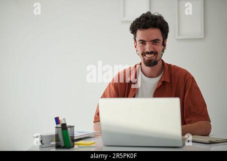 Portrait of happy startupper working on laptop in office Stock Photo