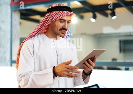 Arab muslim businessman using digital tablet in modern office Stock Photo