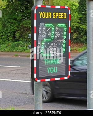 Electronic roadside speed indicator displaying “Your Speed 27” with a “Thank You” message on a residential road in the United Kingdom Stock Photo