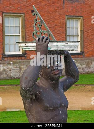 Historic sundial sculpture depicting a Moor figure at Dunham Massey, a National Trust estate near Altrincham, Greater Manchester Stock Photo