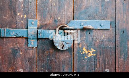 Rusty padlock on an old wooden door close up Stock Photo