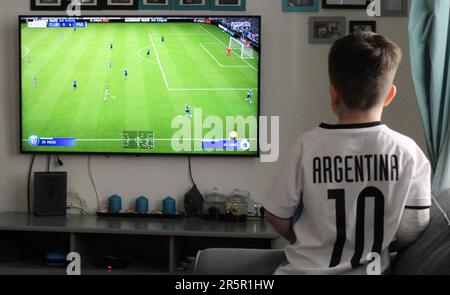 Small boy wears soccer jersey Messi Argentina Team with nr. 10 and plays  football on a TV screen with a Nintendo Switch computer console, Prague,  Cze Stock Photo - Alamy