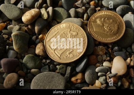 Russian and French old gold coins on stones. Stock Photo