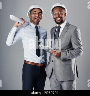 Our minds are our most important tools. two civil engineers discussing building plans while standing in the studio. Stock Photo
