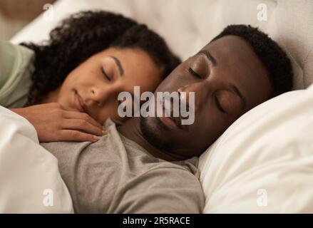 Young multiracial couple sleeping together in bed in the morning Stock Photo