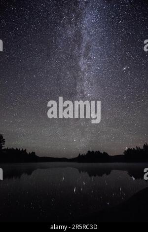 The galactic centre of the Milky Way with countless stars and a visible Andromeda galaxy overlooking Kearney Lake in Algonquin Park Stock Photo