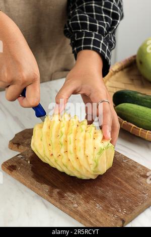 Woman Hand Cut Pineapple in the Kitchen, Process making Tropical Fruit Juice Stock Photo