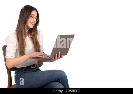 Smiling happy caucasian woman holding and working on laptop. Side view portrait of caucasian businesswoman using notebook. Lifestyle concept idea. Stock Photo