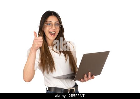 Woman holding laptop. Newest notebook in her hand, showing thumb up. Approval, recommend concept advertising idea. Using computer, shopping, surfing. Stock Photo