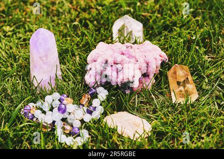 Collection of natural mineral crystals on green grass, esoteric healing lifesytle concept Stock Photo
