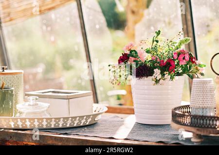 Beautiful bouquet of garden flowers in sunny rustic kitchen Stock Photo