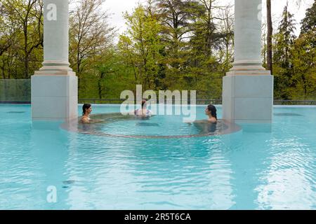 France, Meurthe et Moselle, Nancy, Nancy Thermal includes on the one hand the historic spa building built in 1913 by architect Louis Lanternier and the extension of the existing building by architects Anne Demians member of the Academie des Beaux Arts (academy of fine arts) in the architecture section and Nicolas Chabanne located in the Artem district on Rue du Sergent Blandan, the outdoor nordic pool for hydrotherapy of the thermal spa in the Espace Bien etre (Wellness area) and Sainte Marie public parc in the background Stock Photo