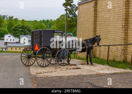 An Amish Buggy and horse parked next to a building in Amish Country in rural, Ohio, USA Stock Photo