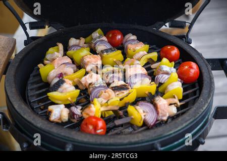 ready to eat - grilled shrimps with salmon and vegetables from a bbq grill at a summer day on the balcony Stock Photo