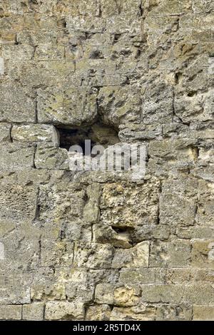 Background and texture of an ancient wall, full frame. There is a hole in the damaged wall. Selective focus. Stock Photo