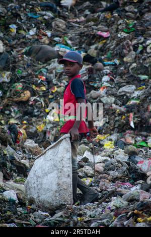 GUWAHATI, INDIA - JUNE 4: A child ragpicker collect reusable items at ...