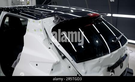 Installing a protective film on the car paintwork. Professional installation of a protective film on a car body. Car wrapping with vinyl film or film Stock Photo