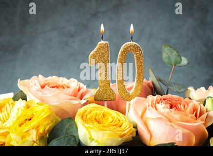 Gold glitter number 10 celebration candle with flowers Stock Photo