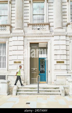 Security guard paces outside british government offices (Cabinet Office) on Whitehall, London, England. Stock Photo