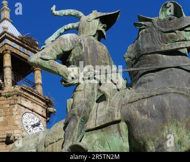 Detail of the equestrian statue of the conquistador Francisco Pizarro in the square of Trujillo with the bell tower of the church of San Martín Stock Photo