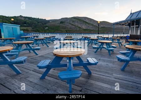 Llandudno north Wales united kingdom 02 June 2023 Blue table's and seat's on Llandudno Pier during a quiet evening Stock Photo