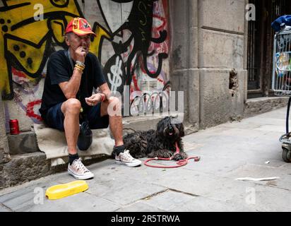 A drunk homeless beggar in the street of the city of Barcelona, Spain Stock Photo