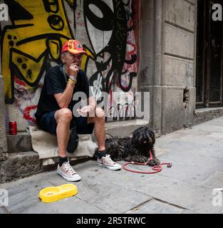 A drunk homeless beggar in the street of the city of Barcelona, Spain Stock Photo